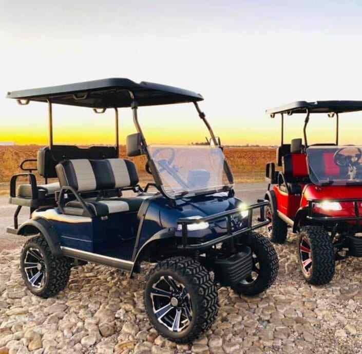 Two golf carts parked side by side on a sunny day, outdoor view